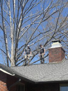 Skyline Contracting staff on top of a black roof doing roof inspections in Gainesville, GA